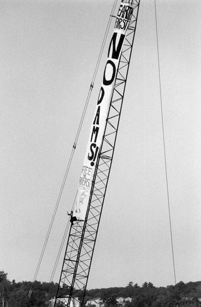 A climber on crane protests the construction of a hydroelectric dam on the Winooski River in solidarity with Vermont's Abenaki tribe. (1992) - PHOTO COURTESY OF ORIN LANGELLE