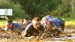 Competitors crawl through a mud pit during the 2012 Walter N. Levy Marine Corps Endurance Challenge at Norwich University