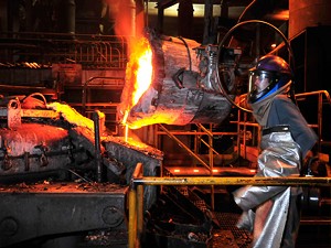 JEB WALLACE-BRODEUR - Eric Shepard pours molten metal from a ladle into a furnace at the Vermont Castings foundry in Randolph