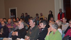 Burlington residents listen to Tom Angotti speak at Contois Auditorium.