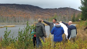 State officials and Adirondack Club and Resort representatives discussing the proposal alongside Cranberry Pond in 2011