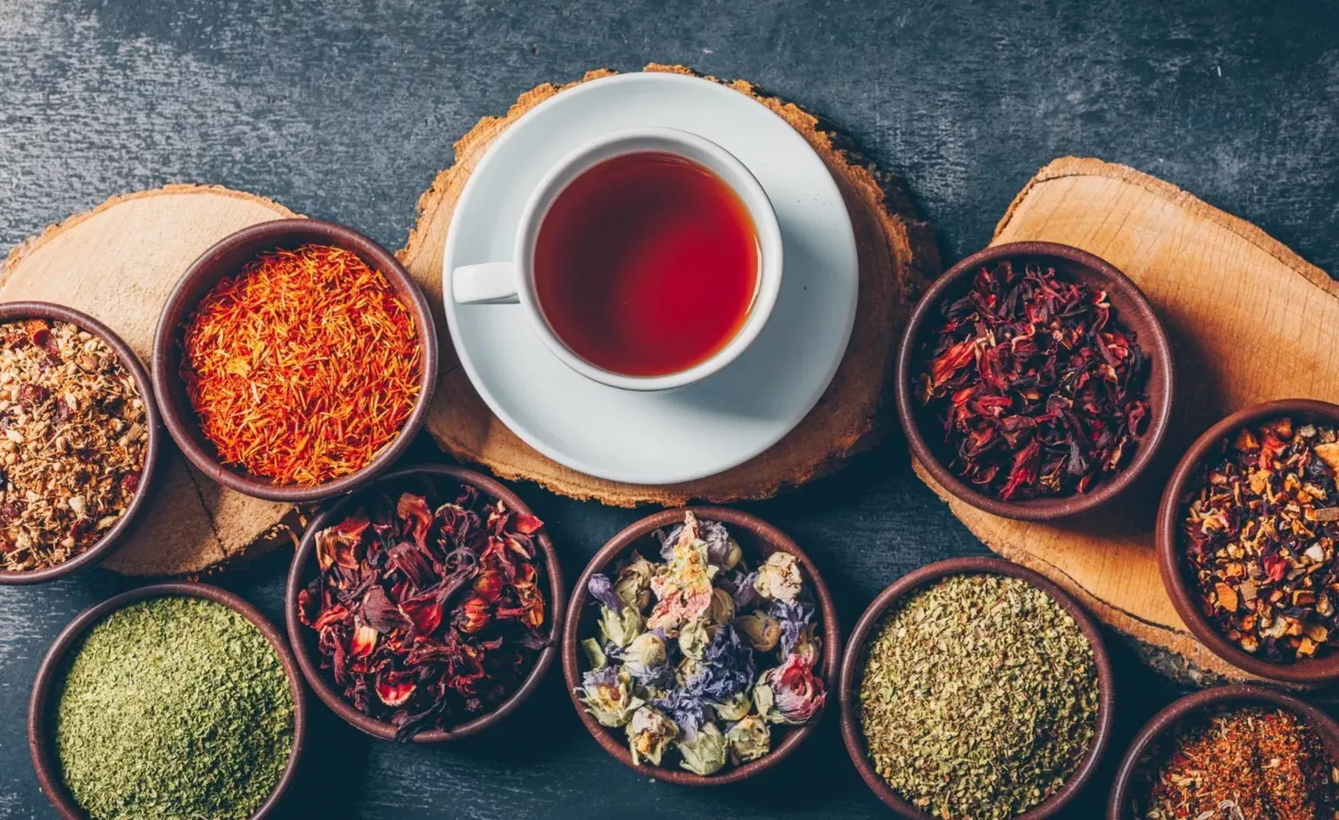 set-wood-stubs-cup-tea-tea-herbs-bowls-dark-textured-background-flat-lay-1559982027.webp