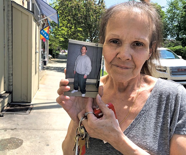 Nancy Davis holding up a photo of her incarcerated son, Jason Anderson - ALICIA FREESE