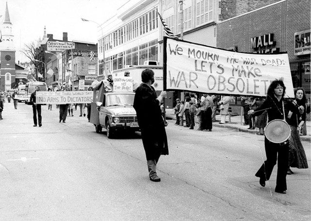 Robin Lloyd banging a drum on Burlington's Church Street with the Peace &amp; Justice Center's Wendy Coe in the background, circa 1980 - COURTESY OF GREG GUMA
