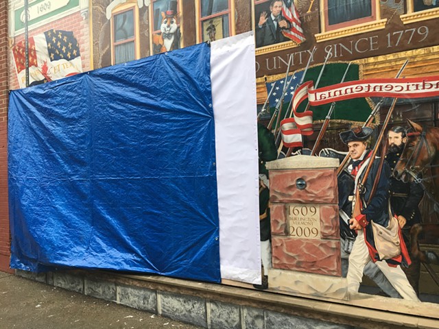 A tarp covers the vandalized section of the "Everyone Loves a Parade!" mural in Burlington. - MATTHEW ROY