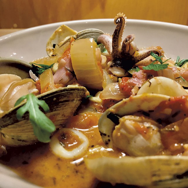 Clam saut&eacute; with squid, olives and prosciutto in tomato broth - COURTESY OF CHIP NATVIG