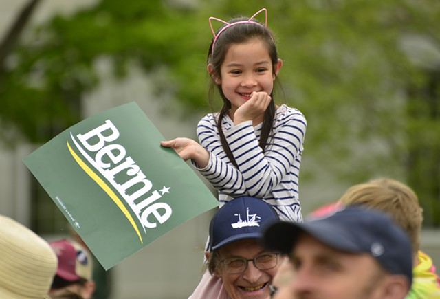 Mai Huynh Parke, 6, of Montpelier takes in the crowd from atop the shoulders of her dad, Ethan, 68, during a Bernie Sanders rally Saturday in Montpelier. - STEFAN HARD