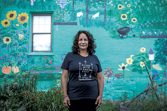 Gina Carrera standing in front of her mural on South Champlain Street - LUKE AWTRY