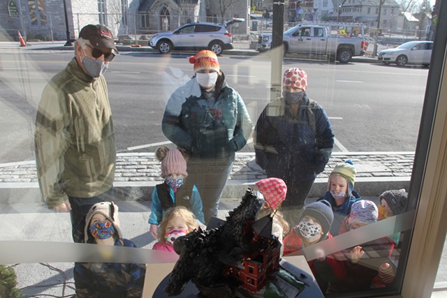 Passersby admiring "Mutant Otters Destroy Town Hall Theater" - COURTESY OF DANIEL HOUGHTON