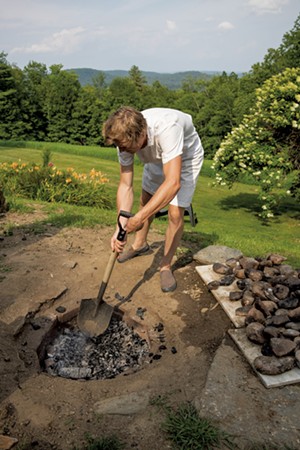 Nevin Taylor preparing the firepit for a clambake - ZACHARY P. STEPHENS