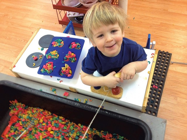 Levi playing with multicolored macaroni at Wildflower Studio