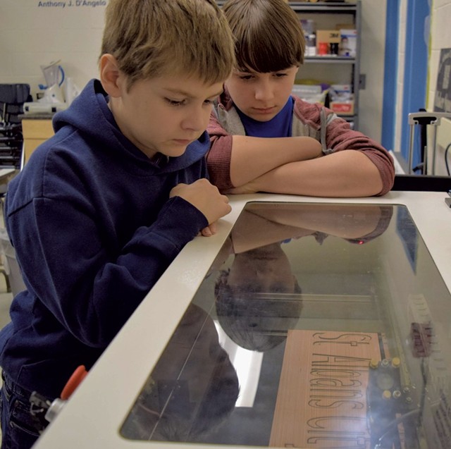 St. Albans City School students watching the laser cutter work its magic
