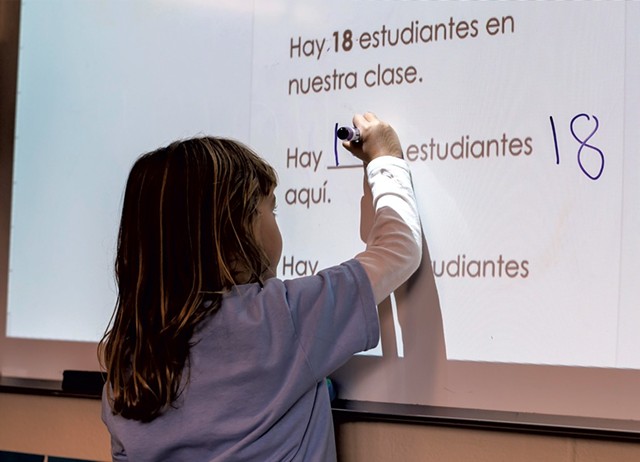 A Spanish immersion kindergartner fills in the blank on the whiteboard - GLENN RUSSELL