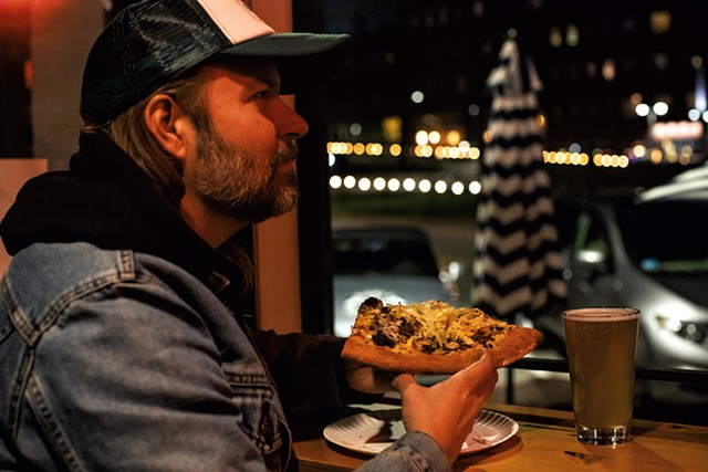 Danny LeFrancois, of Danny &amp; the Parts, enjoying a brew and a slice of the McMonkey pizza - LUKE AWTRY
