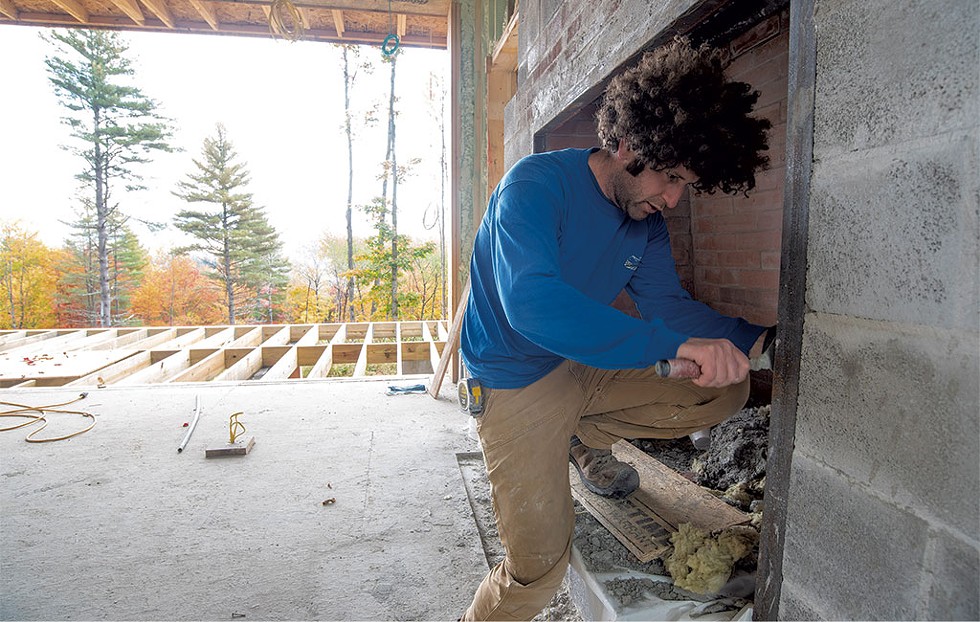 Dave Torres working on a fireplace in a new home under construction in Stowe - JEB WALLACE-BRODEUR
