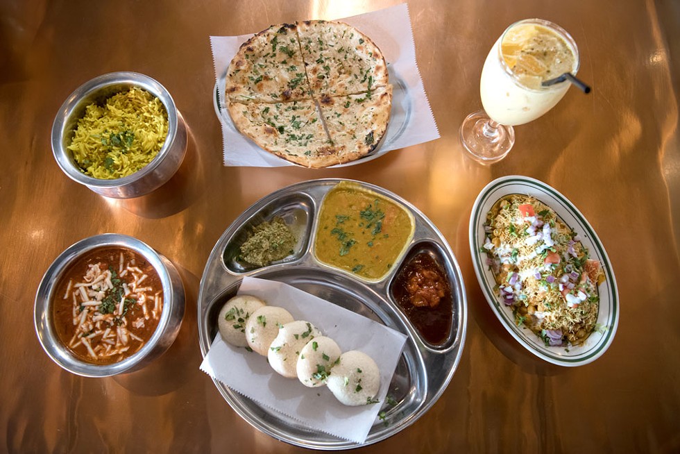 Clockwise from top: Garlic naan, mango lassi, samosa chaat, idli sambar, paneer masala and rice - DARIA BISHOP