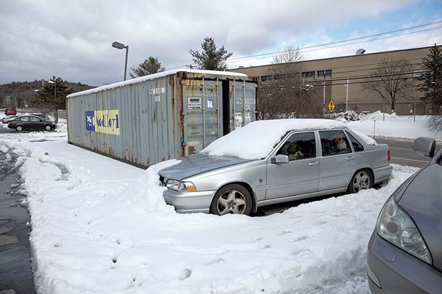 Cars filled with personal items and open shipping containers in the parking lot of the Quality Inn - ZACHARY P. STEPHENS
