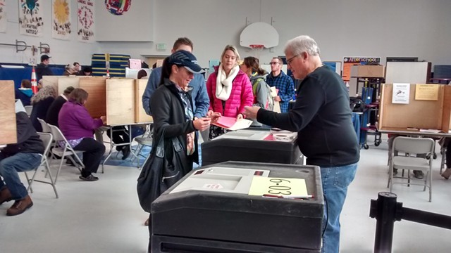 Voters line up to cast their ballots at the Sustainability Academy at Lawrence Barnes. - KATIE JICKLING