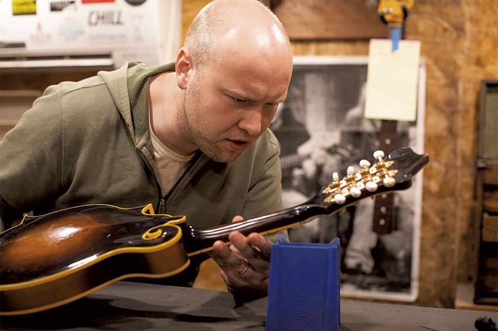 Micah Plante inspecting a mandolin at his shop in Bristol - LUKE AWTRY
