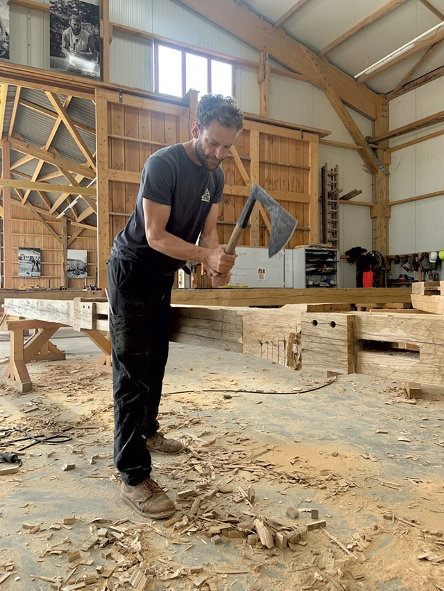 Will Wallace-Gusakov hand-hewing oak beams for the Notre-Dame nave roof frame - COURTESY OF WILL WALLACE-GUSAKOV