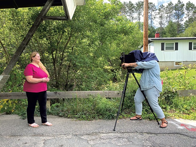 Monica Jane Frisell taking Beverly's portrait in front of the Chamberlin Mill Covered Bridge in Lyndon - HANNAH FEUER