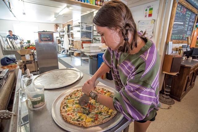 Sadie Mikovitz slicing a Farm + Forage pizza - JEB WALLACE-BRODEUR