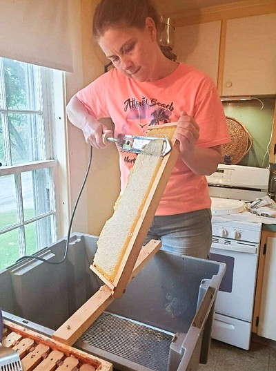 Laura Johnson harvesting honey - COURTESY