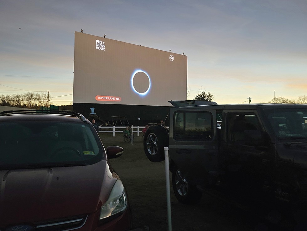 A screen showing the eclipse at the drive-in - CHRIS FARNSWORTH ©️ SEVEN DAYS