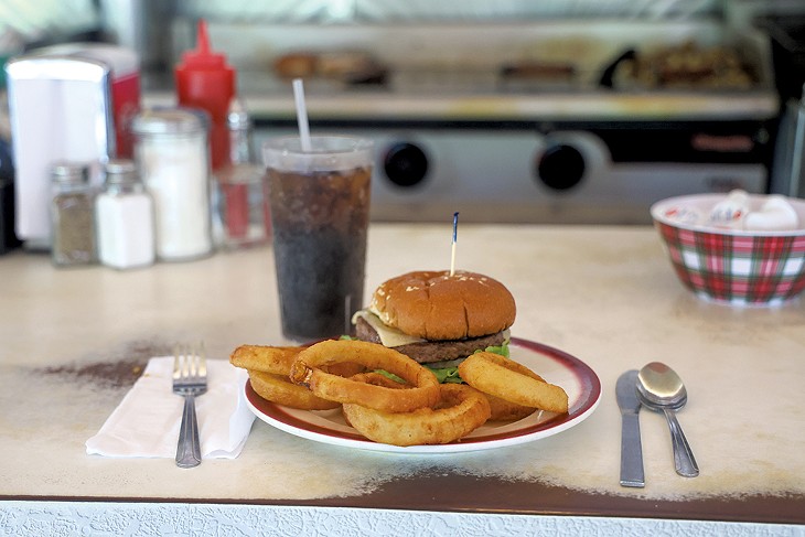 A burger with onion rings - STEVE LEGGE