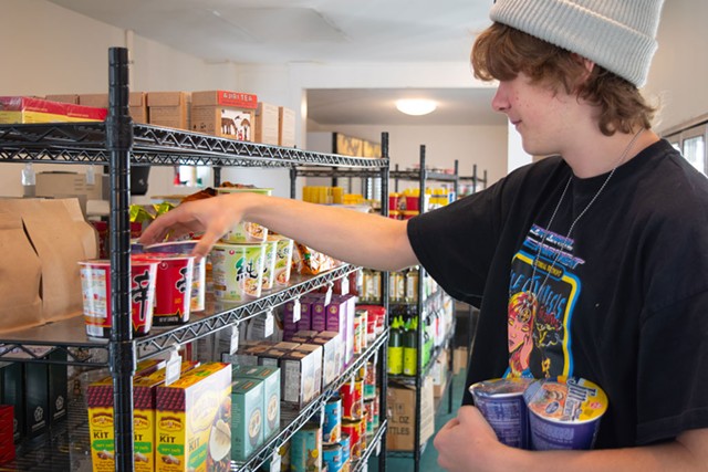 Moses Kokernot stocking shelves at Meadow Mart in Montpelier