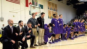Saint Michael's College men's basketball players kneel during the anthem in an exhibition game at the University of Vermont