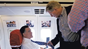 Mitt Romney (left) and Stuart Stevens talking aboard the Romney campaign plane in October 2012