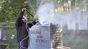 Jim Woodman cleaning mold and lichen off a headstone