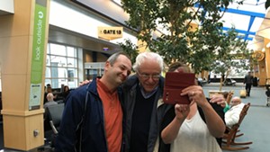 Sen. Bernie Sanders poses for selfies at Burlington International Airport Friday on his way to a debate in Des Moines.
