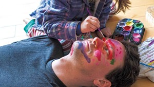 Torrey Valyou gets his face painted by 5-year-old daughter Lily at their home in Burlington