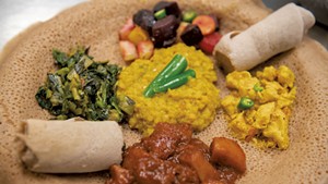 Ethiopian and Eritrean lentils, carrots, beets and potatoes, collard greens, curried chicken, and spicy potatoes, served on injera bread, for a takeout dinner at the O'Brien Community Center