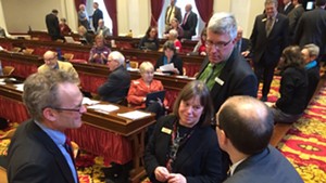 Reps. Willem Jewett (D-Ripton), Helen Head (D-South Burlington) and Tom Stevens (D-Waterbury) confer with Damien Leonard, one of the legislature's lawyers, about the paid sick leave bill.