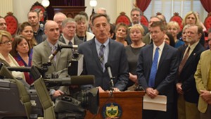 Gov. Peter Shumlin prepares to sign a bill requiring employers to provide paid sick leave.