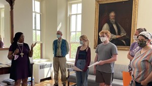 Bishop Shannon MacVean-Brown speaking with students in front of the portrait of John Henry Hopkins that has been removed