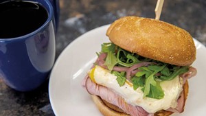 Breakfast sandwich with ham, arugula and pickled red onions