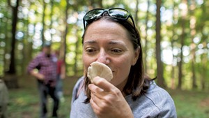 Brooke Cutlan of West Bolton smelling a mushroom during a foraging walk at Shelburne Farms