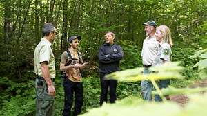 U.S. Forest Service employees talk with participants at the Rainbow Family gathering.