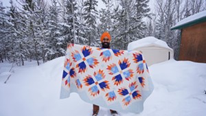 Gurdeep Pandher at home with a quilt made by Beth Norris of Wheelock