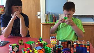Brady solves a puzzle while his mom looks on