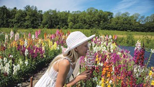 Astri Feiker smelling the flowers at her family's Glory Flower Farm in Charlotte