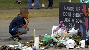 A young boy at the Michael Brown memorial site in Ferguson, Mo.