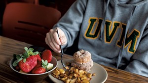A UVM student eating home fries made with local potatoes