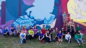 Champlain College students in front of their mural with Anthill Collective