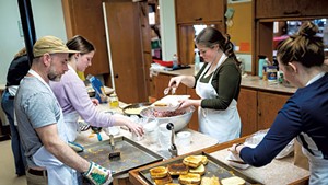 From left: Teacher Josh Fox and students Ella Considine, Lily Castle and Maverick Murphy packing to-go meals at the United Church of Hardwick