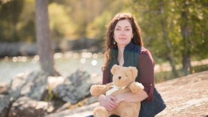 Chelsea Levis holding a teddy bear calibrated to her son Timothy's weight